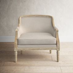 a white chair sitting on top of a hard wood floor next to a gray wall