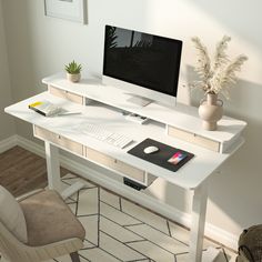 a white desk with a computer monitor and keyboard