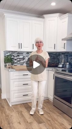 an older woman is standing in the kitchen