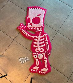 there is a pink sticker on the floor with a skeleton and apple in it