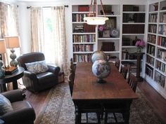 a living room filled with furniture and bookshelves covered in lots of bookcases