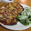 a white plate topped with food next to a salad