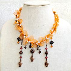 This vibrant pumpkin orange braided lace chunky necklace combines bold color with eclectic charm. The necklace features a thick, intricately braided lace in a lively orange hue, creating a striking and playful contrast. Accentuating the bold lace are brass-tone charms, which add a touch of vintage sophistication and texture. The chunky design ensures a statement-making presence, while the combination of orange and brass provides a unique, eye-catching appeal. Ideal for adding a pop of color and a touch of artisanal flair to both casual and dressy outfits, this necklace is a standout piece that effortlessly blends contemporary style with bohemian charm. Chunky Necklace, Bold Color, Dressy Outfits, Pumpkin Orange, Bold Colors, Halloween Shopping, Contemporary Style, Necklace Etsy, Color Pop