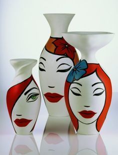 three vases with faces painted on them and one has a bow in its hair