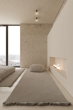 a room with a bed, fireplace and large window overlooking the cityscape in the distance