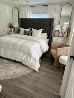 a large white bed sitting inside of a bedroom