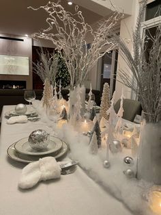 the table is set with silver and white decorations