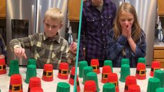 two boys and a girl standing in front of a table full of plastic cups that have been placed on top of each other