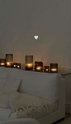 a white couch with candles on it in front of a window