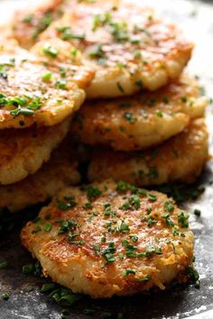 some crab cakes are stacked on top of each other and garnished with parsley