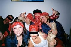 a group of people wearing red bandanas posing for the camera