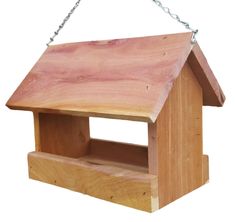 a wooden bird house hanging from a chain