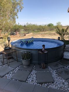 an empty swimming pool in the middle of a yard with rocks and gravel around it