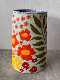 a ceramic vase with flowers and leaves painted on it