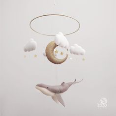 a baby crib mobile with a whale and moon hanging from it