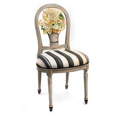 an antique chair with flowers painted on the back and upholstered in black and white stripes