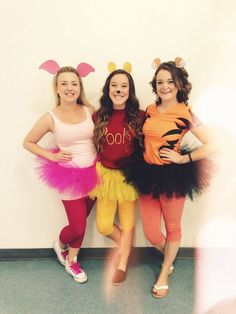 three girls dressed up in costumes posing for the camera