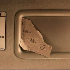 a piece of paper with the words i love you written on it next to a sign