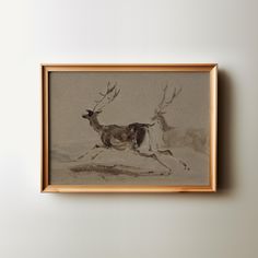 a painting hanging on the wall with a deer running in it's right hand