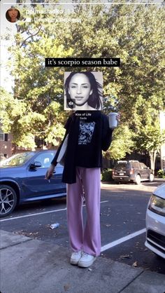 a woman standing on the side of a road holding a coffee cup