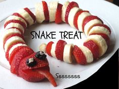 a snake made out of strawberries and bananas on a plate with the words snake treat