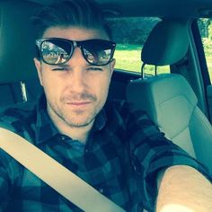 a man wearing sunglasses sitting in the back seat of a car