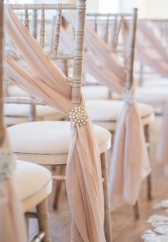 the chairs are decorated with pink sashes and ribbons for an elegant touch to the wedding ceremony