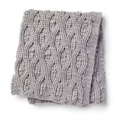 two gray knitted dishcloths sitting on top of each other, one with an intricate design