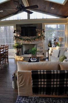 a living room filled with furniture and a flat screen tv mounted to the wall above a fireplace