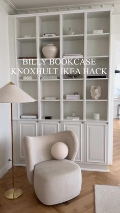 a white chair sitting in front of a book shelf