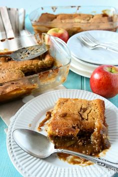 a slice of apple pie on a plate with a fork and glass dish full of apples in the background