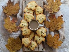 some leaves and a cup of coffee on a wooden tray with burlooms