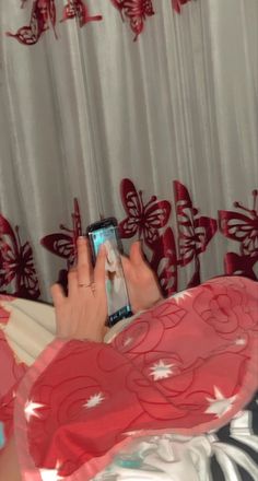 a woman laying in bed while using her cell phone