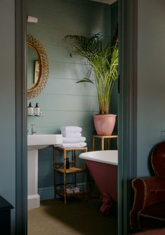 a bath room with a tub a sink and a mirror on the wall next to a chair