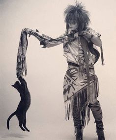 a woman in costume standing next to a cat