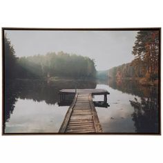 a wooden dock sitting on top of a lake next to a forest filled with trees