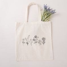 "Flower Tote Bag Cute Tote Bag Floral Tote Aesthetic Bag Market Bag Tote Bag Pattern Canvas Tote Bag Shoulder Bag Shopping Bag Cute Tote Bags One canvas tote bag with original hand drawn wildflower artwork, perfect for bridesmaid gifts, reusable shopping bags, measuring at 15.75\"h x 15.25\"w and with a handle length of 21.5\" 100% cotton sheeting Reinforced handle stitching One size Designed with Love" Eco-friendly Tote Bag For Personal Use, Large Capacity Tote Bag For Personal Use, Eco-friendly Pouch Bags For Daily Use, Eco-friendly Bags With Removable Pouch For Gifts, Eco-friendly Bag With Removable Pouch For Gift, Eco-friendly Bag With Removable Pouch As Gift, Wildflower Artwork, Bridal Party Getting Ready, Flower Tote Bag