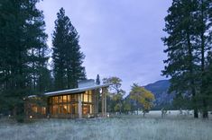 a house in the middle of a field surrounded by trees