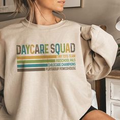 a woman wearing a sweatshirt that says day care squad