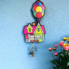 a house shaped key holder with a balloon attached to it