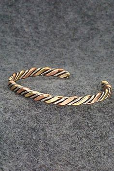 This copper, nickel and brass bracelet was made by Navajo silversmith Verna Tahe.Size: 5 1/8" (will fit up to a 6 1/8" wrist)Gap: 1"Width: 1/4"Free shipping on all orders! We ship with USPS and always include tracking. All orders ship within a day of payment.Returns are accepted up to 30 days after you receive your order. Just send us a message. Our shop offers cash back or store credit. The item must be returned in new condition. Adjustable Artisan Metal Bangle, Adjustable Hand Forged Bronze Bracelets, Bohemian Hand Forged Copper Cuff Bracelet, Artisan Silver Copper Cuff Bracelet, Silver Artisan Cuff Bracelet In Copper, Artisan Silver Cuff Bracelet In Copper, Artisan Metal Bracelets Nickel Free, Artisan Silver-colored Copper Cuff Bracelet, Hand Wrapped Silver Copper Bangle