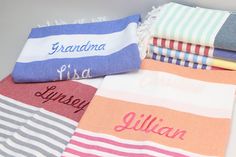 towels with names on them sitting next to each other in different colors and patterns,