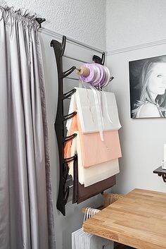 a wooden table sitting next to a wall with pictures hanging on it's sides