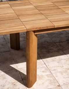 a wooden table sitting on top of a tiled floor