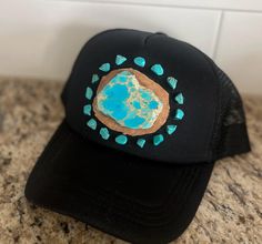 Ready to ship!! Turquoise Stone Embellished Trucker Cap with Larger Stone . Each stone individually placed by hand on the cap. All cap designs and patterns will vary, making each hat unique and 1 of a kind! Additional features: Snap Closure Light-weight, foam-constructed front 5-panel design High profile Curved visor and semi-structured crown One Size fits most Embellishments affixed with glue **WARNINGS** *Keep away from children and pets. We are NOT RESPONSIBLE for any damages or injuries due to misuse. POLICIES: All products are FINAL sale, but should you have an issue, please contact us within 2 days of delivery of your order and I will do my best to resolve it. . Note: Products are handmade and may have slight imperfections. We are NOT RESPONSIBLE for any damages or injuries due to mi Cap Designs, Turquoise Stones, Panel Design, Turquoise Stone, Trucker Cap, Snap Closure, Caps Hats, Accessories Hats, Embellishments