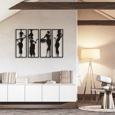 three black and white silhouettes on a wall in a living room next to a table