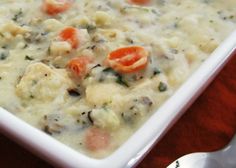 a bowl filled with food sitting on top of a table next to a silver spoon