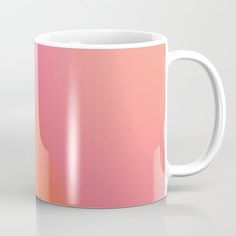 a white and pink coffee mug sitting on top of a table