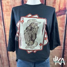 Embrace your wild side with this Vintage Grunge Cowgirl Tee, featuring a bold and unique Ace of Spades playing card design. Perfect for those who love to mix western vibes with a touch of edgy grunge, this graphic tee is a must-have for any wardrobe. Design Details: Ace of Spades Cowgirl: This one-of-a-kind graphic showcases a tattooed cowgirl in a classic playing card style, blending western charm with modern grunge. Unisex Fit: Designed to be worn by everyone, this tee offers a comfortable and Unisex Graphic Print Tops For Fan Merchandise, Unisex Fan Merchandise Top With Front Print, Black Funny Print Band Merch Tops, Black Band Merch Tops With Funny Print, Black Band Merch Top With Funny Print, Black Tops With Funny Print Band Merch, Punk Style Pre-shrunk Relaxed Fit Tops, Punk Relaxed Fit Pre-shrunk Tops, Punk Style Top With Front Print And Relaxed Fit