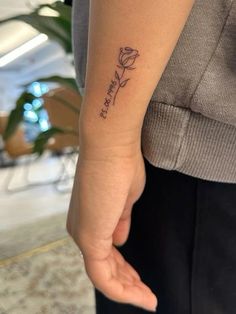 a woman's arm with a small tattoo that reads, love is in the air